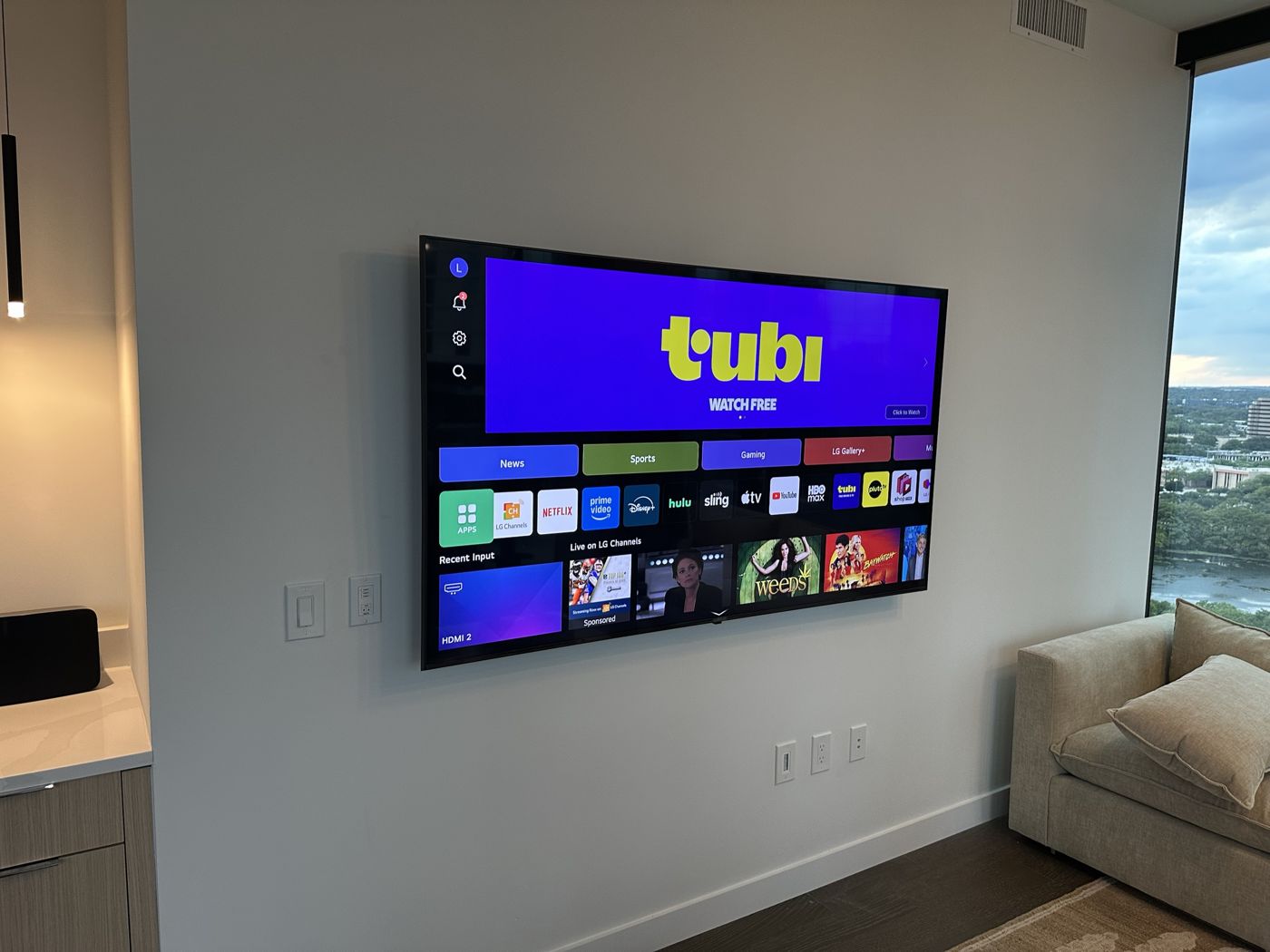 Large LG TV on a condo wall with no cords hanging below it